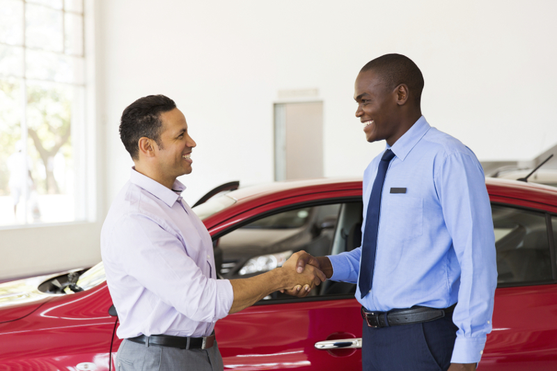 smiling african american car dealer handshake with customer